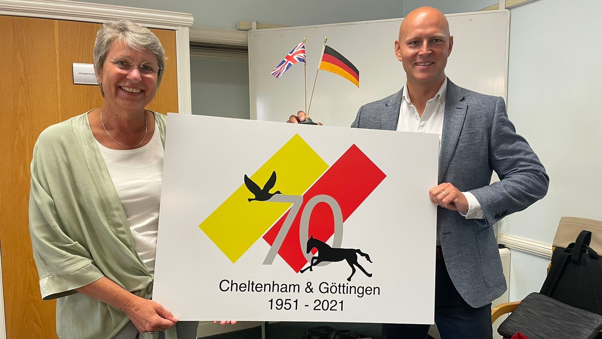 Councillor Max Wilkinson and Mayor of Göttingen holding the Cheltenham and Göttingen 70th anniversary logo